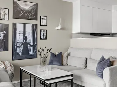 Spisestue med frisk bildevegg bestående av bilder i sort og hvitt, ved åpen løsning for stue og kjøkken